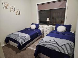 a bedroom with two beds and a window at Tranquil home in Point Cook. in Point Cook