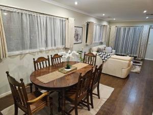 a living room with a table and a couch at Tranquil home in Point Cook. in Point Cook