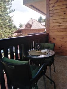 a table and chairs on a balcony with a cup of coffee at Simic Apartmani Tara in Kaludjerske Bare