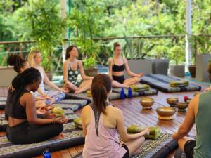 eine Gruppe von Menschen, die in einem Yoga-Kurs sitzen in der Unterkunft CC's Hideaway Kata - SHA Plus in Kata Beach