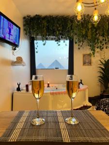 due bicchieri di vino appoggiati su un tavolo di Jacuzzi Pyramids View 5 a Il Cairo