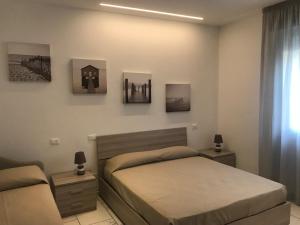 1 dormitorio con 1 cama y algunas fotos en la pared en Da Elena, en San Mauro a Mare