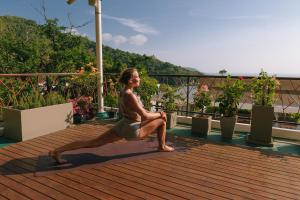 una mujer haciendo una pose de yoga en una cubierta en CC's Hideaway Kata - SHA Plus, en Kata Beach