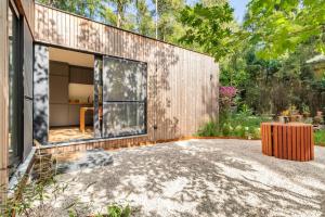 una casa con una gran puerta de cristal en un patio en Luxe-Avontuur in een Romantische Cabin in het Bos, en Stekene