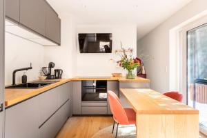 cocina con armarios blancos y mesa de madera en Luxe-Avontuur in een Romantische Cabin in het Bos, en Stekene