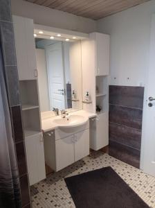 a white bathroom with a sink and a mirror at Øster Hurup in Hadsund