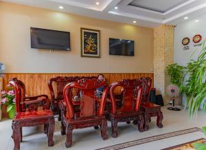a room with a bunch of chairs and a tv at Thi Long Phụng Hotel in Phú Quốc