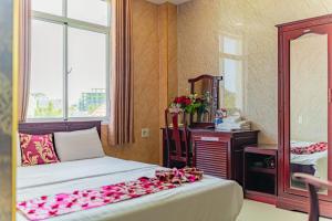 a bedroom with a bed with pink flowers on it at Thi Long Phụng Hotel in Phu Quoc +29 photos
