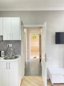 a kitchen with a sink and a door to a room at Allseasons Hotel Gabala in Gabala