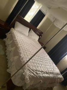 Bett in einem Schlafzimmer mit Fenster in der Unterkunft Orchard Home Homestay in Mbarara
