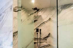 een badkamer met een douche en een marmeren muur bij HOTEL THE MAY Jongno in Seoul