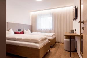 a hotel room with two beds and a window at Obergasserhof Apt Tiroler in Riscone