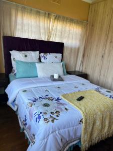 a bedroom with a large bed with a blue comforter at Joyous lodges in Cape Town