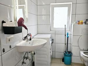 a white bathroom with a sink and a toilet at Work & Stay in Mannheim in Mannheim