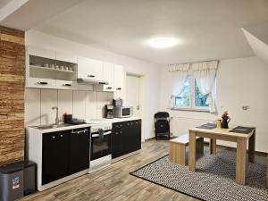 a kitchen with white cabinets and a table in it at Work & Stay in Mannheim in Mannheim