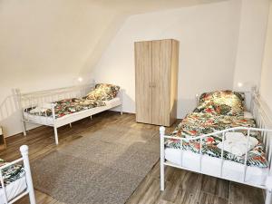 a room with two beds and a cabinet at Work & Stay in Mannheim in Mannheim
