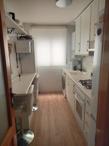 a kitchen with white cabinets and a window at Piso acogedor con terraza in Ciudad Real
