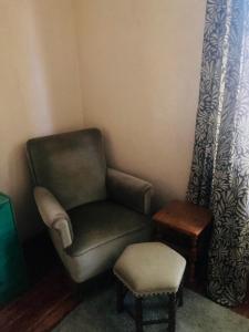 a chair in a corner with a stool and a stool at Стаи за гости "Maroli House 2" 