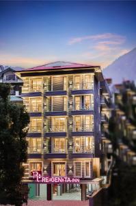a building with a sign on the side of it at Regenta Inn Luxinna Heights Mcleodganj in Dharamshala