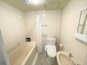 ein weißes Badezimmer mit einer Badewanne, einem WC und einem Waschbecken in der Unterkunft Portside美崎町 離島ターミナル徒歩3分 室内リニューアルOPEN in Ishigaki-jima