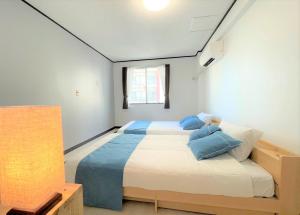 1 dormitorio con 1 cama grande con almohadas azules en Portside美崎町 離島ターミナル徒歩3分 室内リニューアルOPEN en Isla Ishigaki