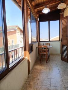 balcone con tavolo, sedie e finestre di Camere A Chiazza Realmonte a Realmonte