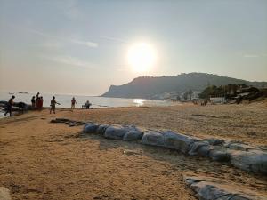 un gruppo di persone su una spiaggia con il tramonto di Camere A Chiazza Realmonte a Realmonte