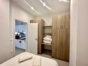 - une chambre avec un lit et un placard avec des serviettes dans l'établissement A13 Athens, à Athènes