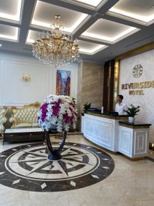 vestíbulo del hotel con recepción y flores en Riverside Hotel Hà Nam, en Phủ Lý