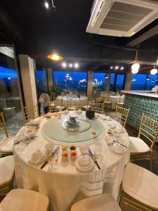 een eetkamer met een tafel met witte tafellakens bij Riverside Hotel Hà Nam in Phủ Lý