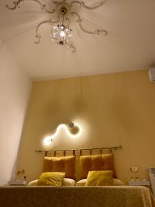 a bedroom with a bed with a chandelier above it at B&b regina del porto in Porto Empedocle