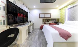 a hotel room with a large bed and a tv at Hera drive in hotel in Jeju