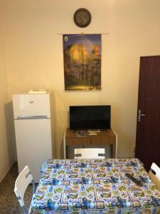 a room with a refrigerator and a table with a bed at Struttura Alloggio Fabrizio Rimini in Rimini