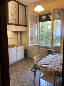 a kitchen with a table and chairs and a table and a window at Struttura Alloggio Fabrizio Rimini in Rimini