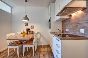 a kitchen and dining room with a wooden table and chairs at Berolina Wohnung 300 in Dahme