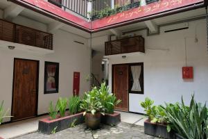 a building with two doors and plants in front of it at Mawar Asri Hotel in Yogyakarta