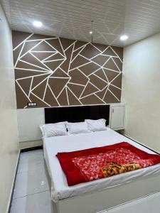 Una cama con una manta roja en una habitación en Hotel shree Gajanand palace, en Ujjain