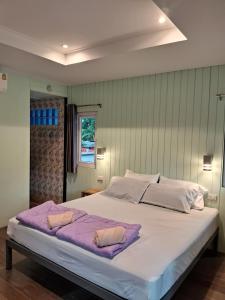 a large white bed with two pillows on it at Rabbit House in Ban Han Tra Fang Nua
