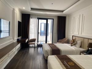 um quarto de hotel com duas camas e uma varanda em Riverside Hotel Hà Nam em Phủ Lý