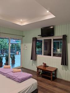 1 dormitorio con 2 camas, mesa y TV en Rabbit House, en Ban Han Tra Fang Nua