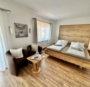 Habitación con cama, sofá y mesa. en Gästehaus Wiesegg, en Reit im Winkl
