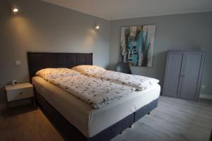 - une chambre avec un grand lit et du parquet dans l'établissement Bootsmann, à Brasilien