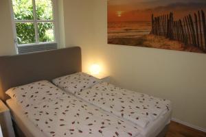的住宿－Wasserrose，卧室内的一张床铺,墙上有绘画作品