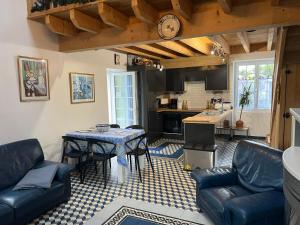 a kitchen and living room with a table and chairs at LA CHEVRIÈRE EN PERIGORD in Villetoureix