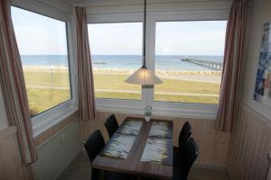 a dining room with a table and a view of the ocean at Ostseeblick in Schönberger Strand