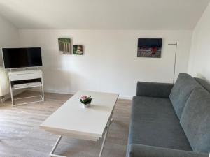 ein Wohnzimmer mit einem Sofa und einem Tisch in der Unterkunft Kleine Galerie in Schönberger Strand