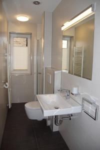 ein Badezimmer mit einem Waschbecken, einem WC und einem Spiegel in der Unterkunft Kira in Schönberger Strand