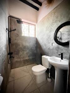 a bathroom with a toilet and a sink at Villa Euphoria - Adults Only in Paje
