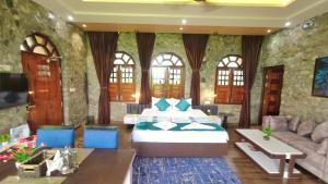 ein Hotelzimmer mit einem Bett und einem Sofa in der Unterkunft The GreyStone FarmHouse, Turibari in Ranīchera