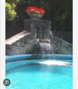 una cascada en una piscina con una fuente en Casa gelsomino, en Fivizzano